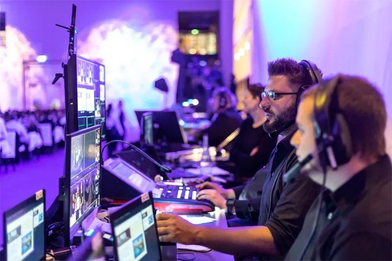 Production team at a live control desk with monitors and headsets